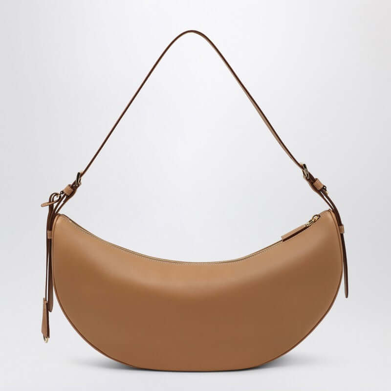 Tan handbag with a shoulder strap on a light gray background