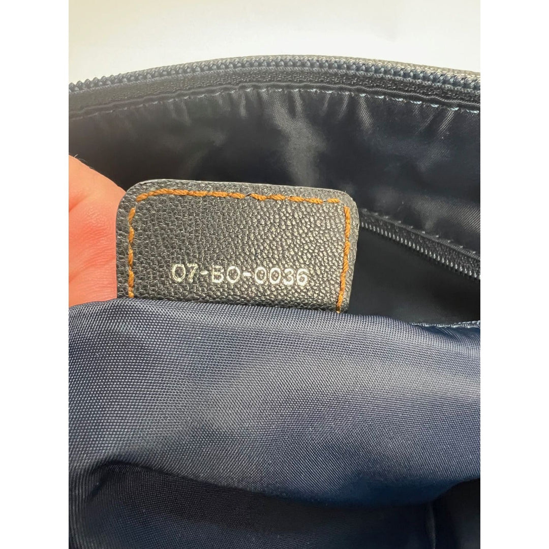 Interior tag of CHRISTIAN DIOR Monogram Trotter CD Blue Canvas Hand Bag, showcasing serial number and craftsmanship details.