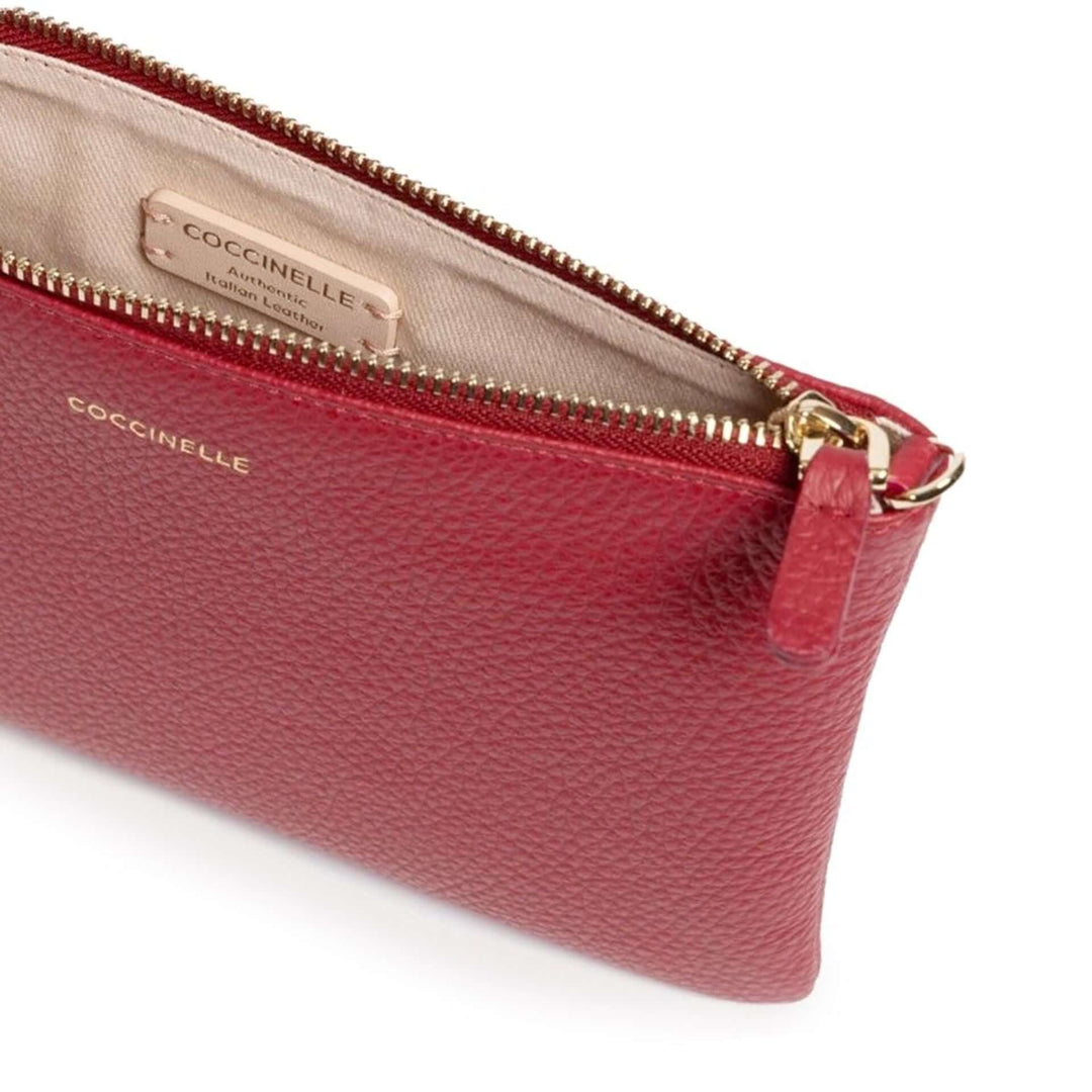 Red leather wallet with gold zipper and Coccinelle branding on a white background