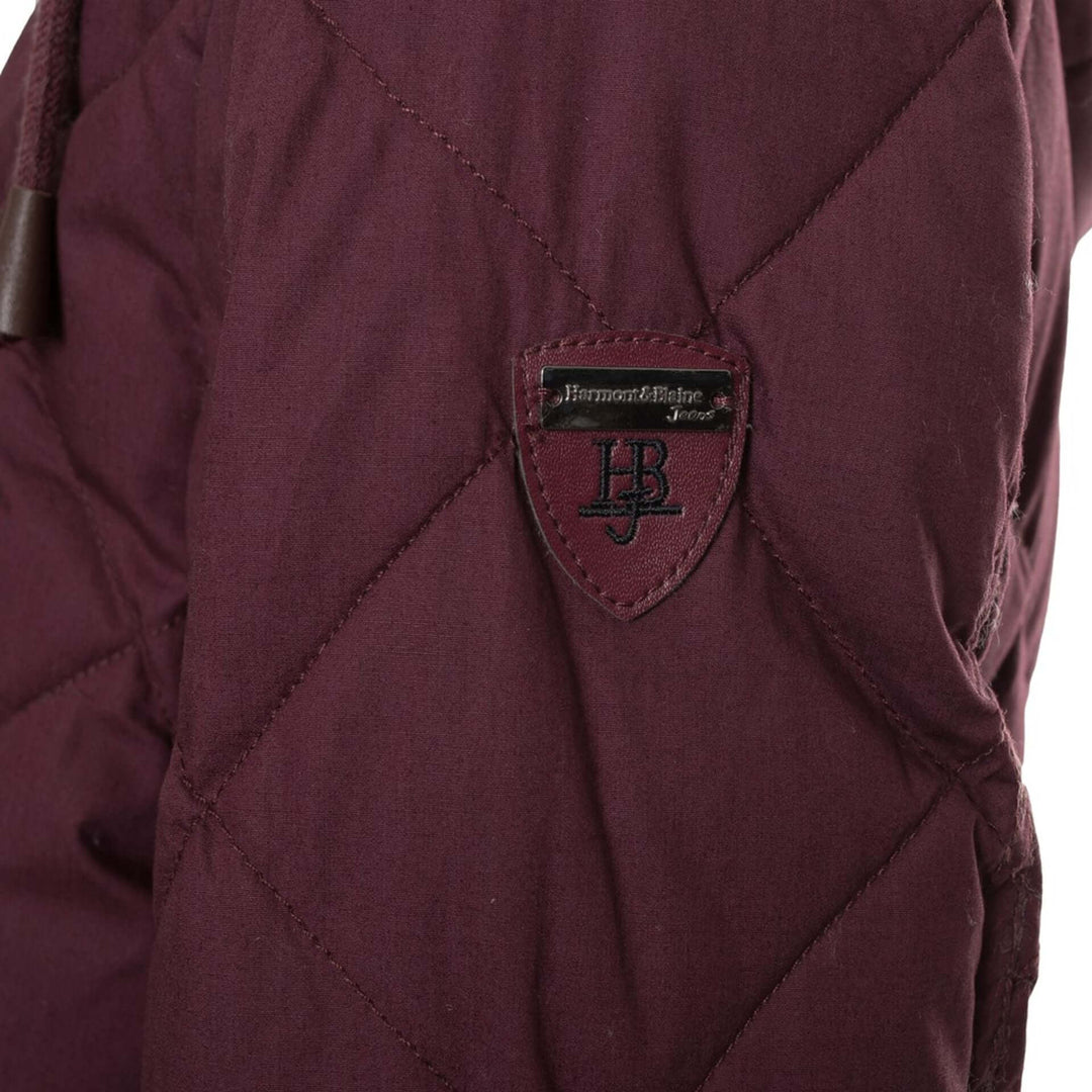 Close-up of a maroon jacket with a brand logo on a white background