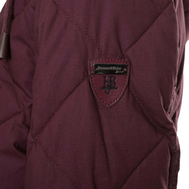 Close-up of a maroon jacket with a brand logo on a white background