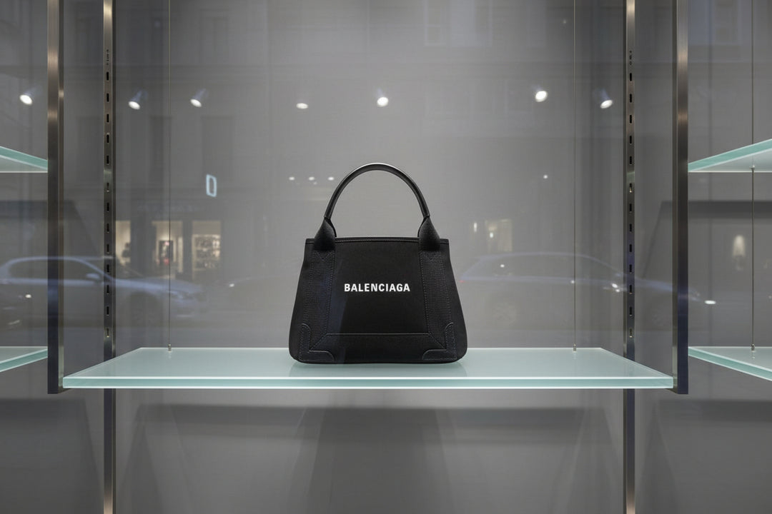 Black Balenciaga handbag with silver handle on a white background