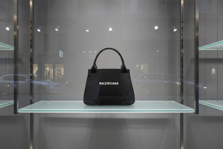 Black Balenciaga handbag with silver handle on a white background