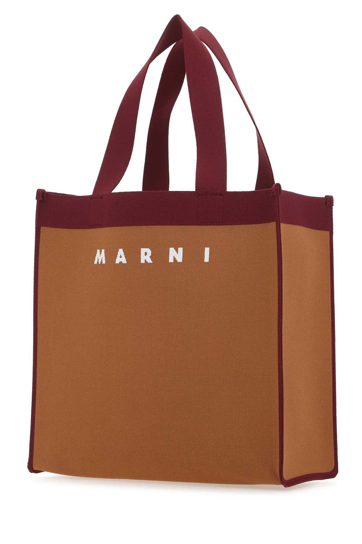 Brown tote bag with red accents and 'Marni' branding on a white background