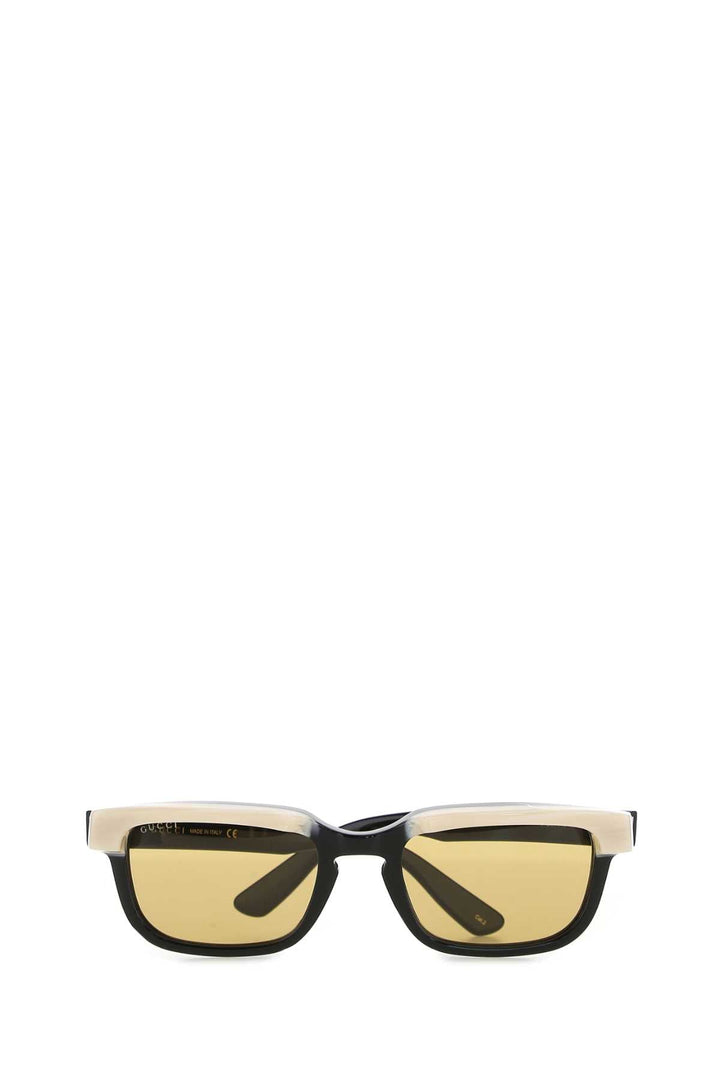 Sunglasses with a black frame and yellow-tinted lenses on a white background