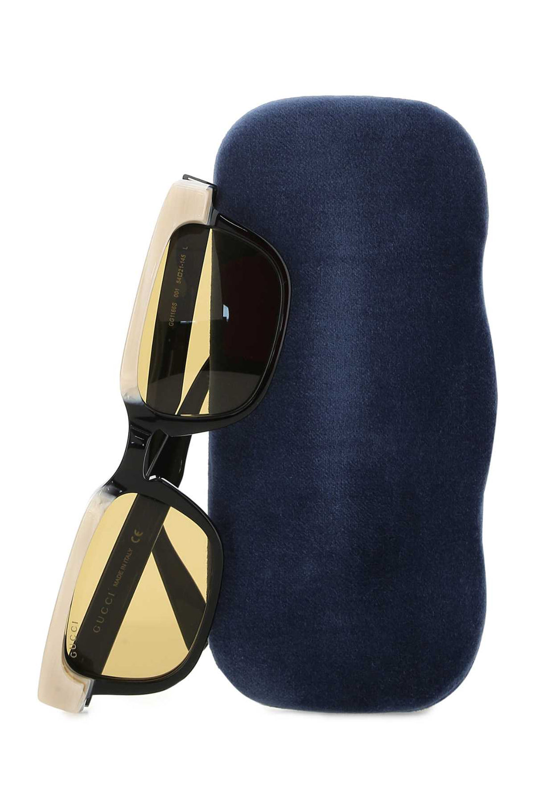 Sunglasses with gold and black frame on a navy blue cushion