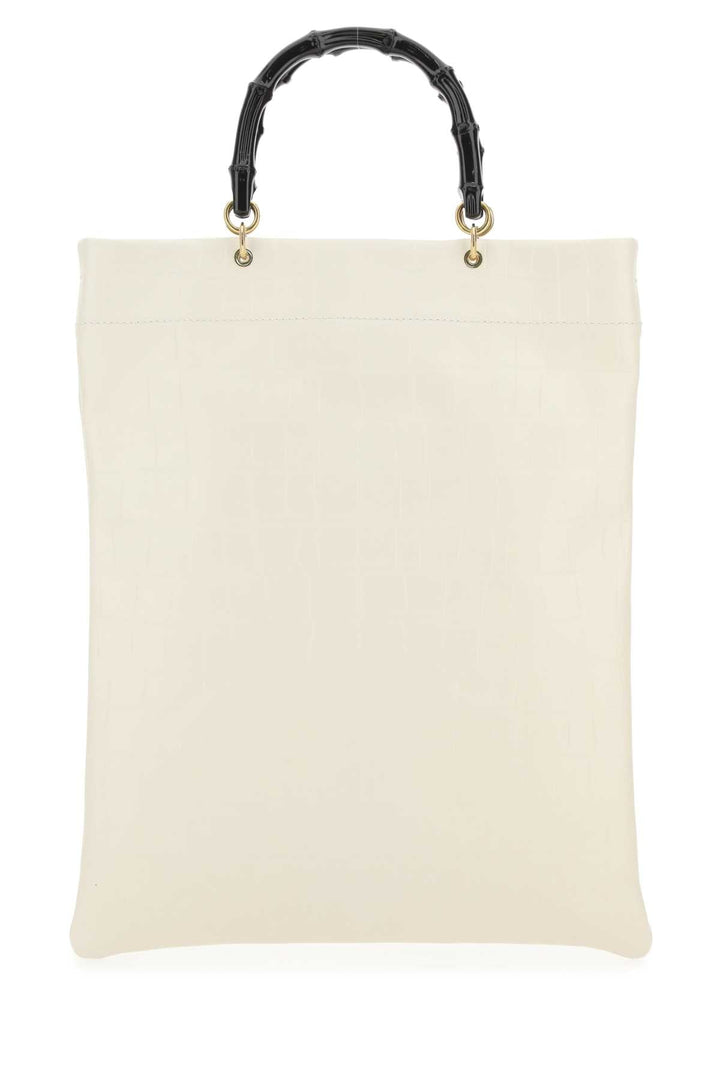 Beige tote bag with black bamboo handle on a white background