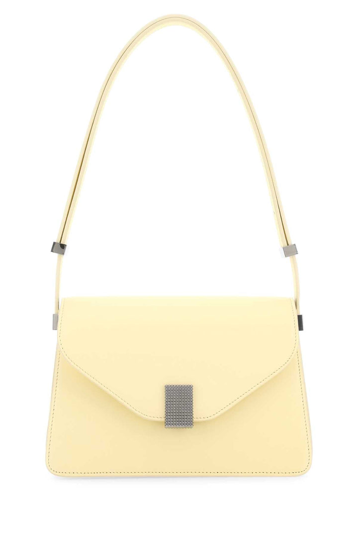 Yellow handbag with a decorative clasp on a white background