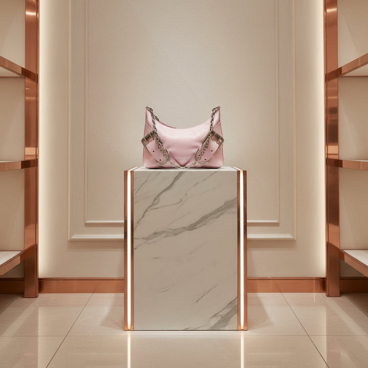 Pink handbag with chain detail on a white background