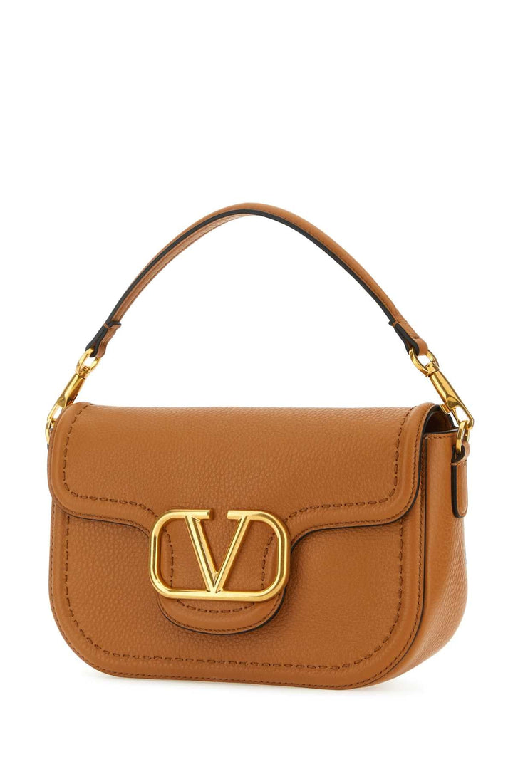 Brown handbag with gold accents on a white background