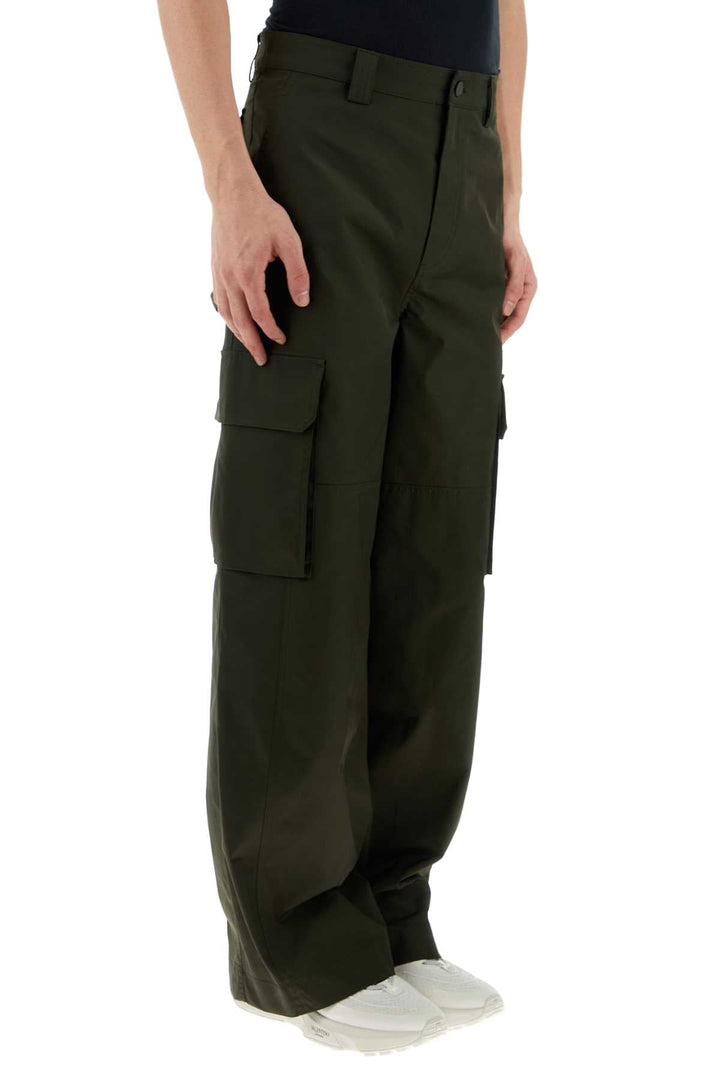 Dark green cargo pants worn by a person on a white background