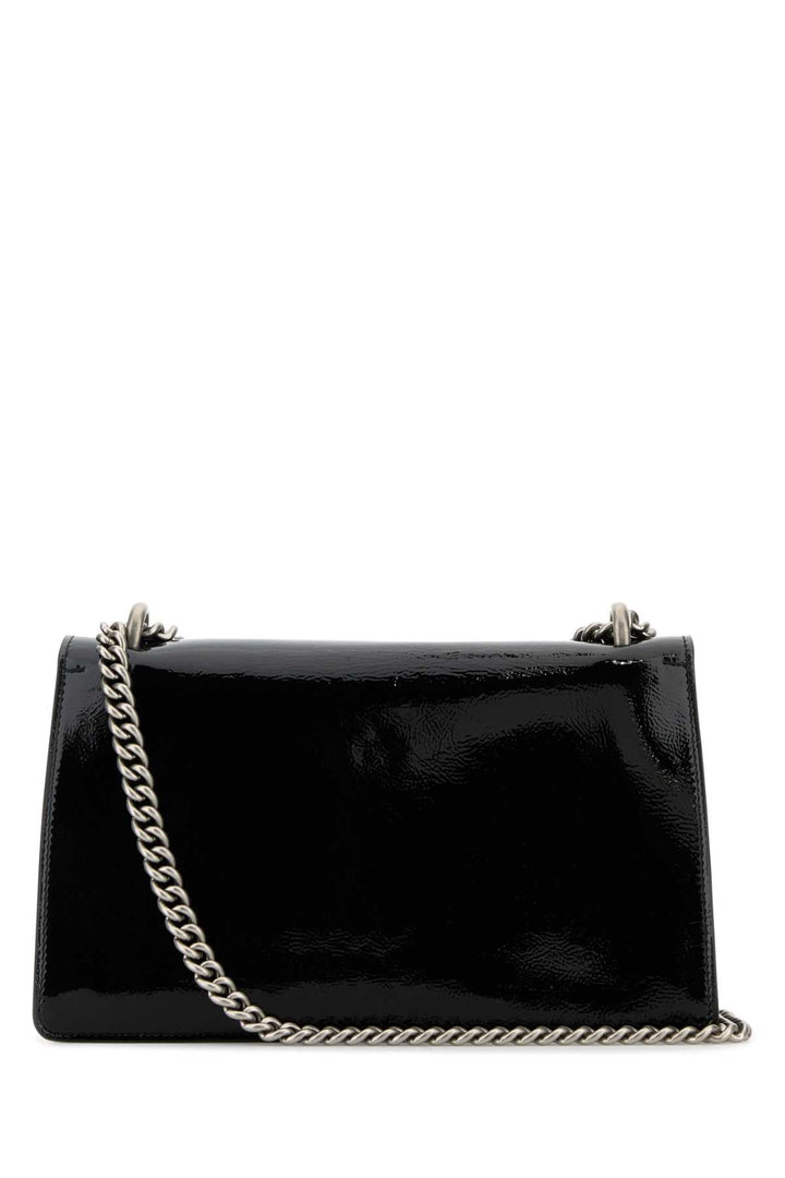 Black patent leather handbag with a chain strap on a white background