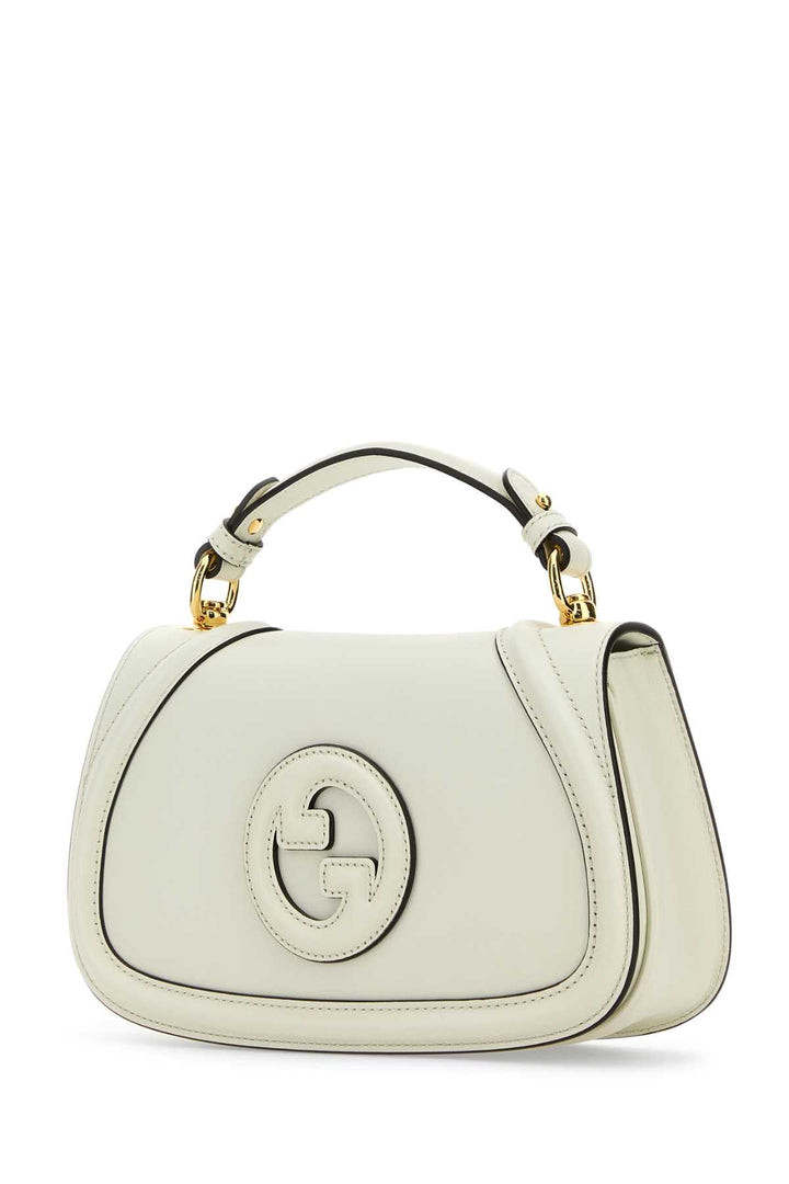 White handbag with gold accents on a white background
