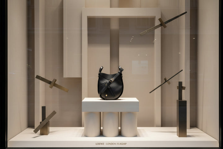 Black leather handbag with gold accents on a white background