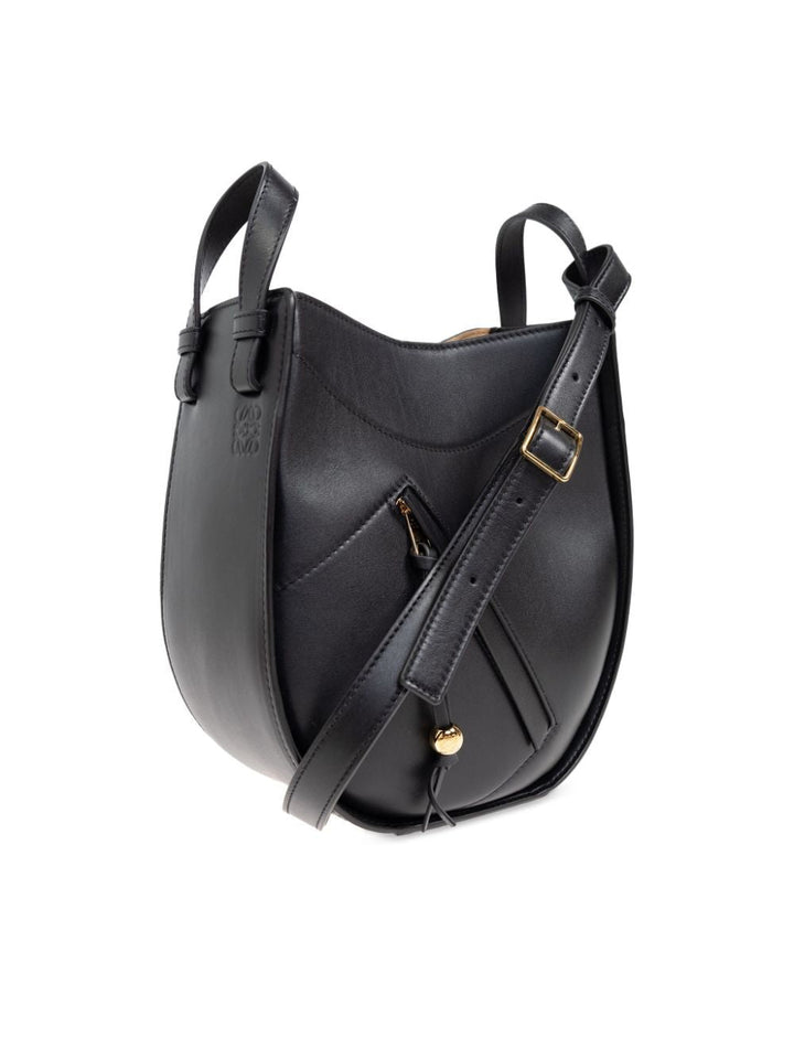 Black leather handbag with gold accents on a white background