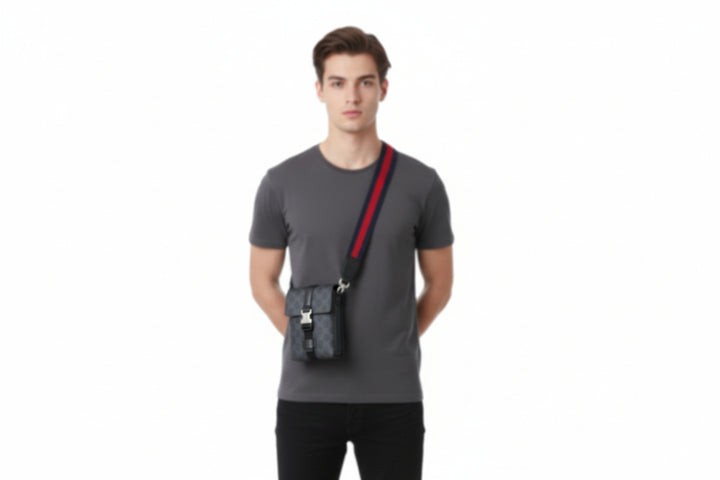 Black patterned bag with red and blue strap on a white background
