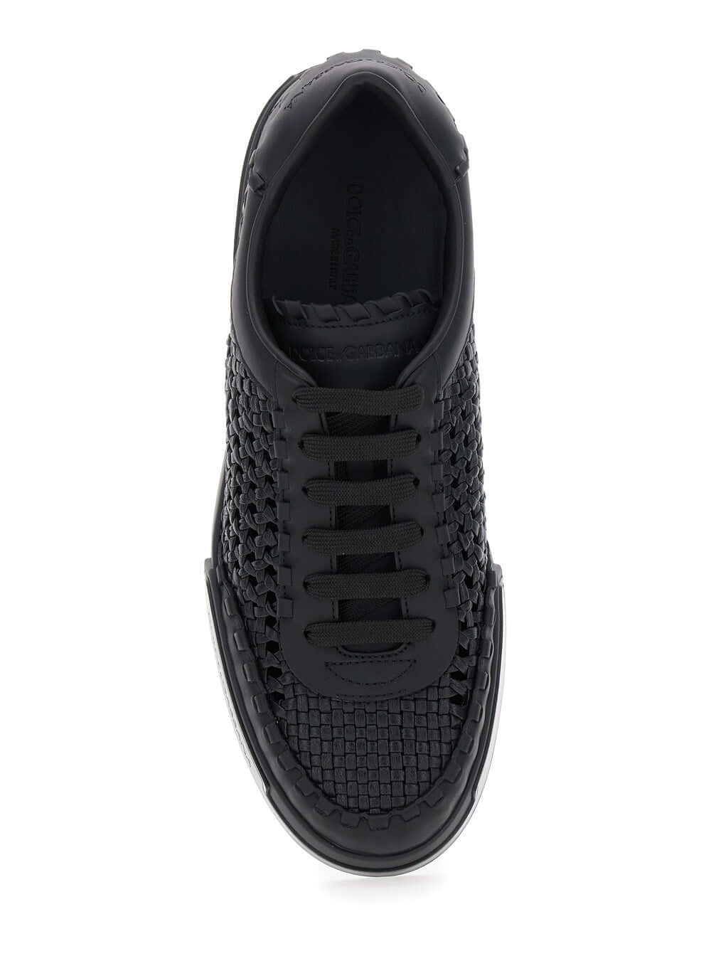Black sneaker with woven pattern on a white background