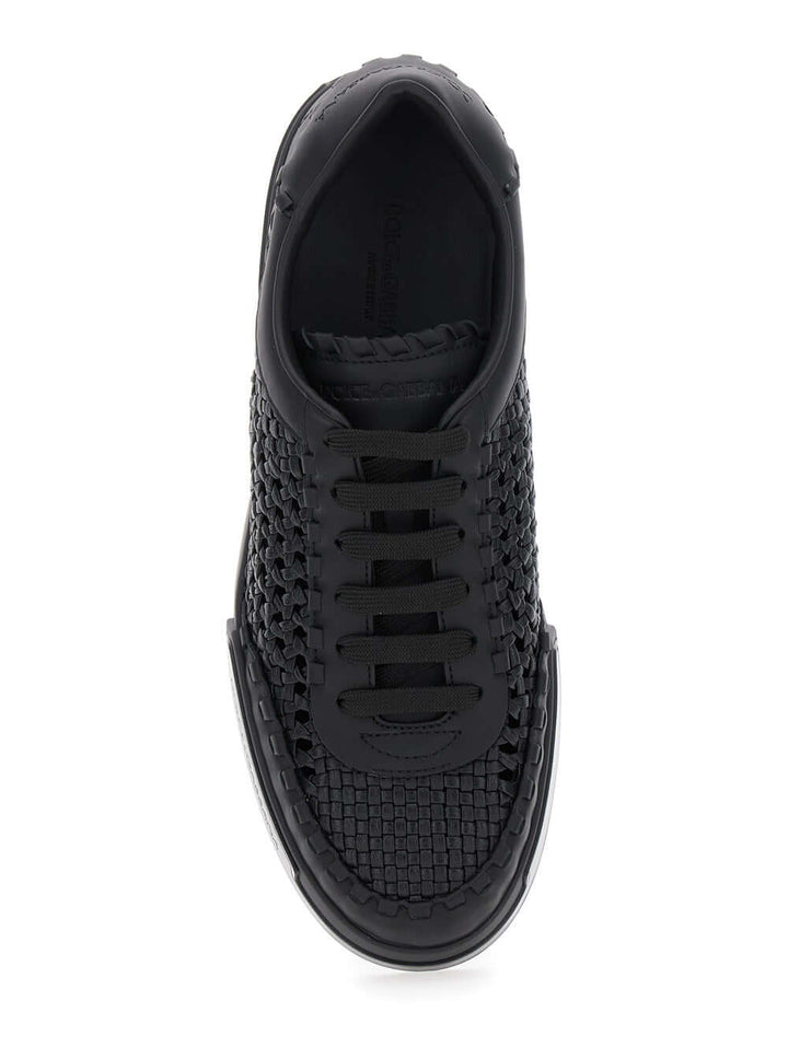 Black sneaker with woven pattern on a white background