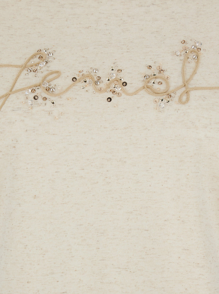 Decorative string with beads spelling 'Felicity' on a textured beige background