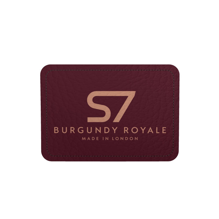 A burgundy leather cardholder or wallet with a debossed gold &