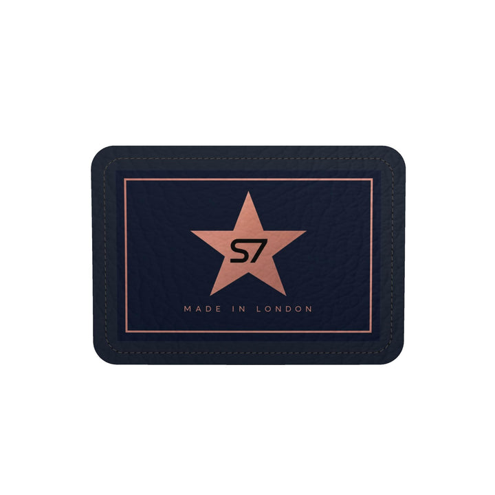 A dark navy blue leather wallet with a central rose gold star logo containing the letters &