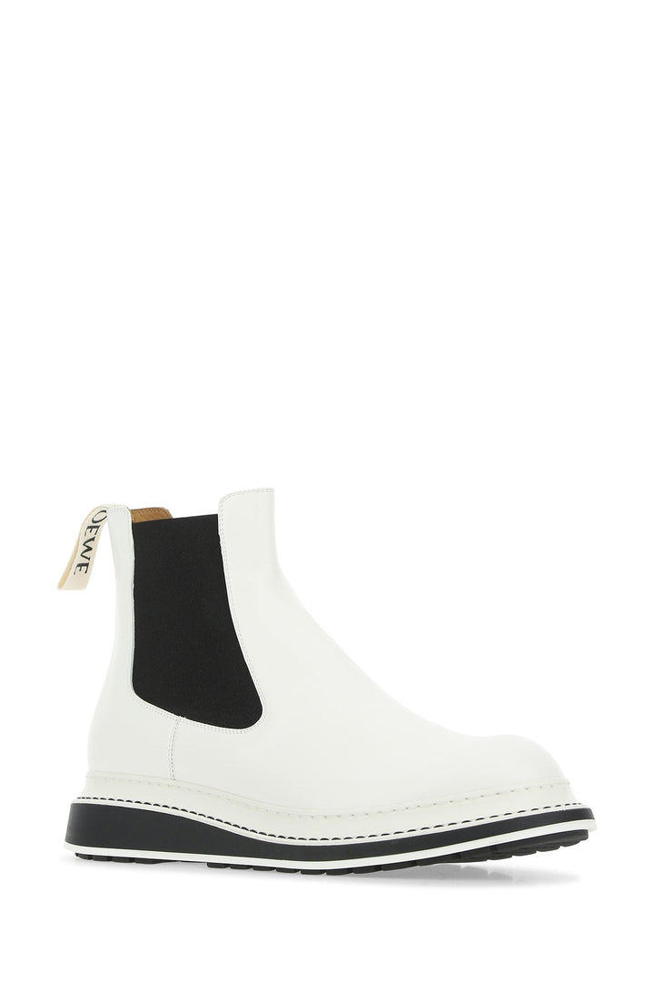 White Chelsea boot with black sole on a white background