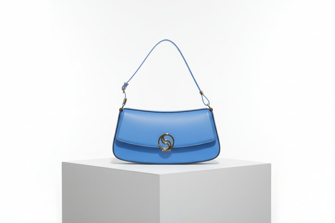 Blue handbag with a gold emblem on a white background