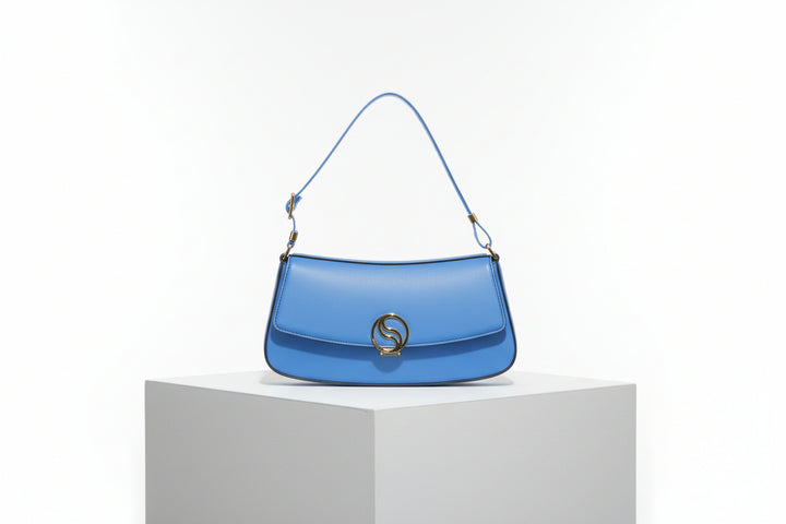Blue handbag with a gold emblem on a white background