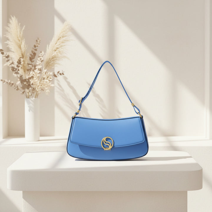 Blue handbag with a gold emblem on a white background