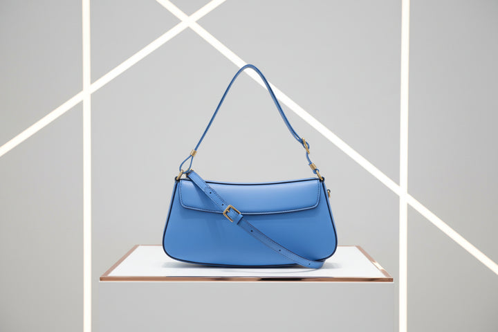 Blue handbag with a strap on a white background