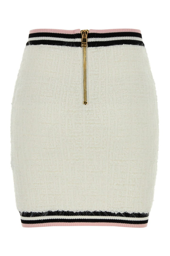 White skirt with black and pink striped hem and gold zipper on a white background