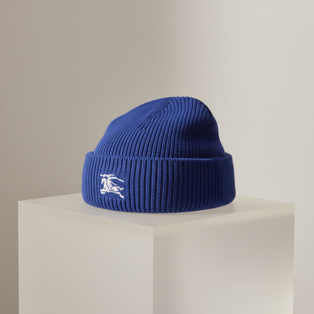Blue knit beanie with a white logo on a white background
