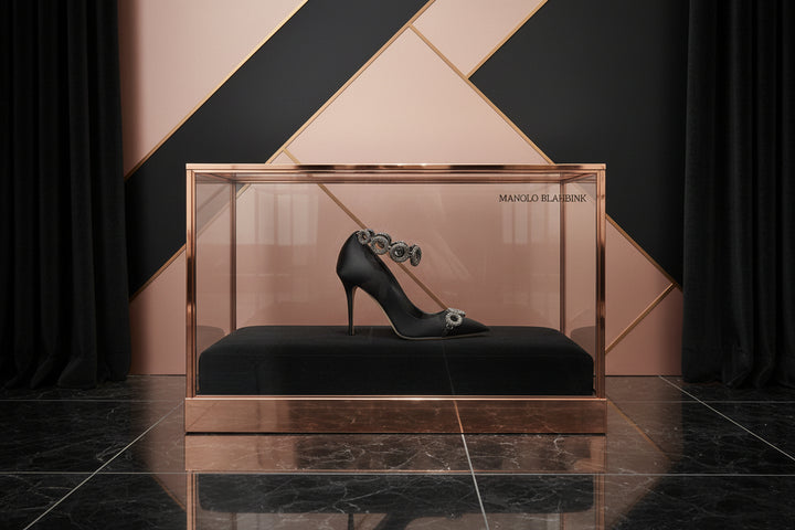 Black high-heeled shoe with decorative ankle strap on a white background