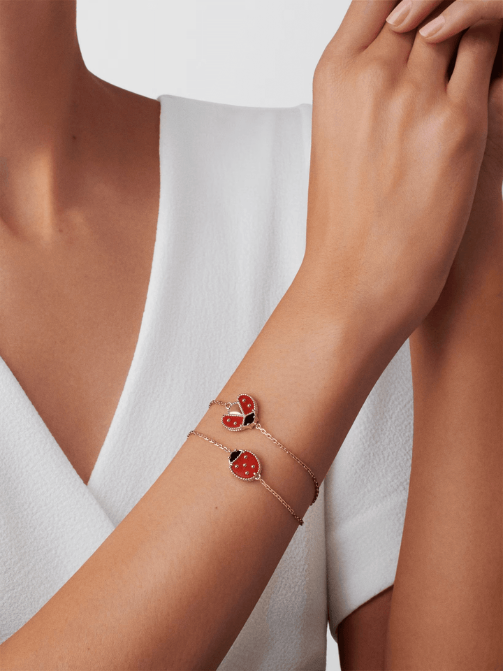 Van Cleef & Arpels Lucky Spring bracelet, open wings ladybug 18K rose gold, Carnelian, Onyx worn on a woman's wrist.