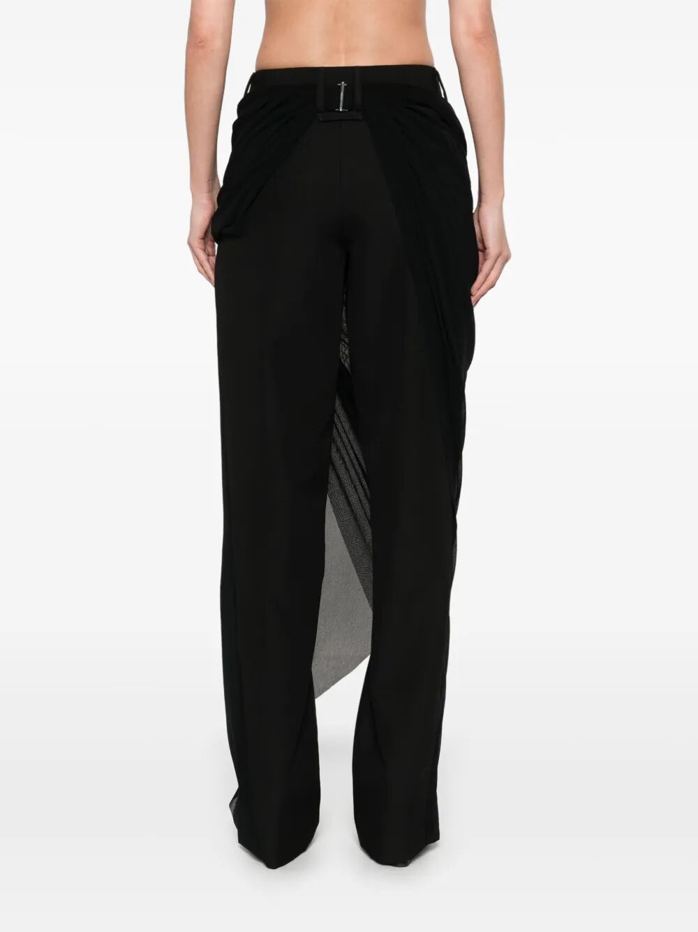 Black pants with sheer side panels worn by a person on a white background