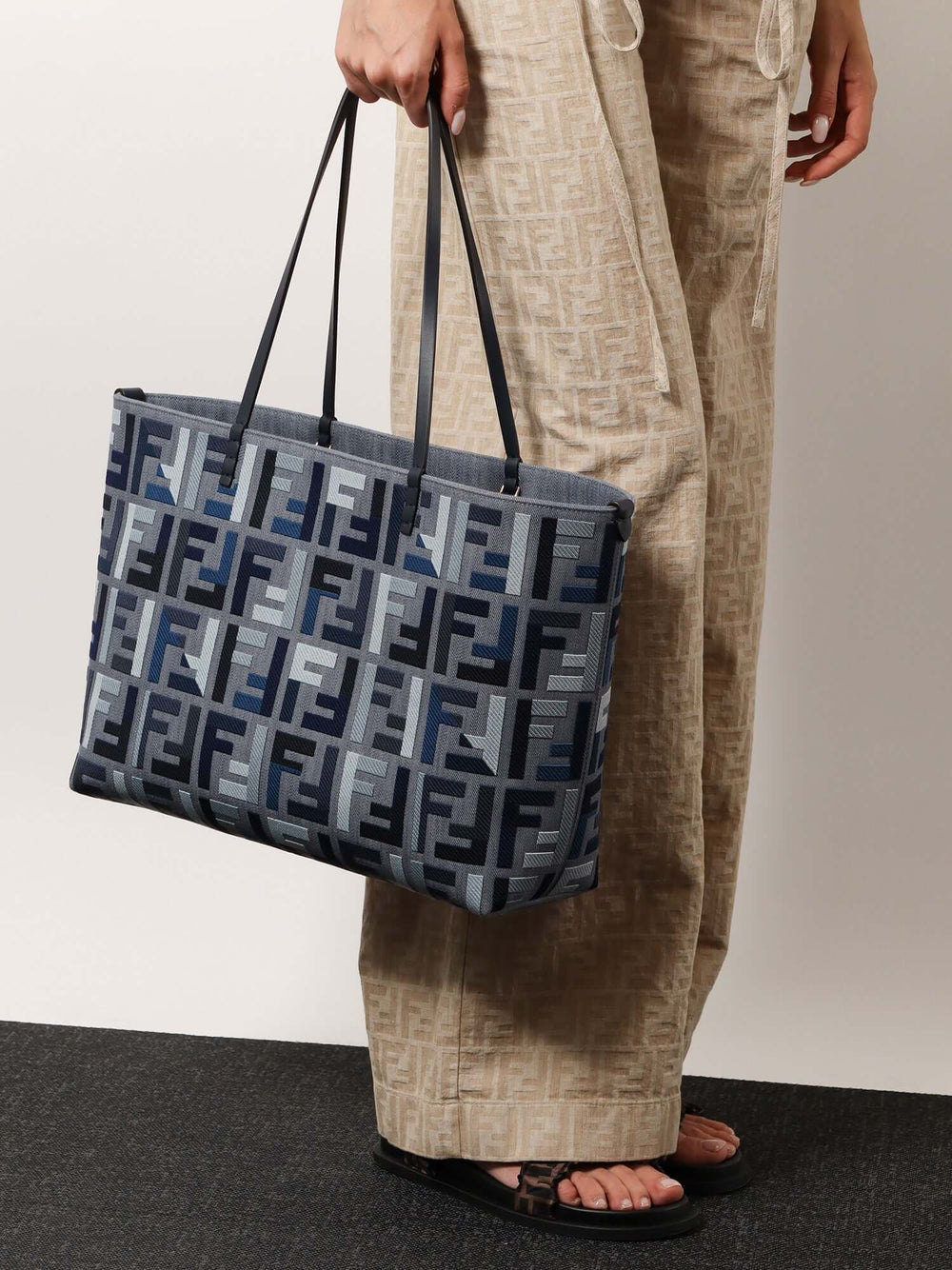 Person holding a patterned tote bag with a neutral background
