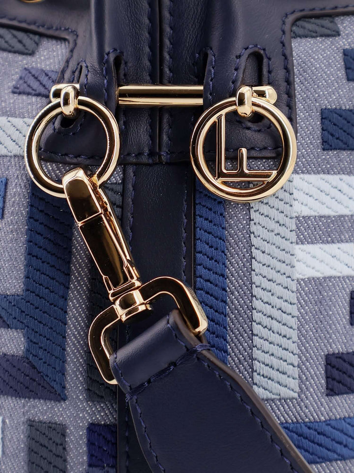 Gold clasp and keychain on a blue textured bag