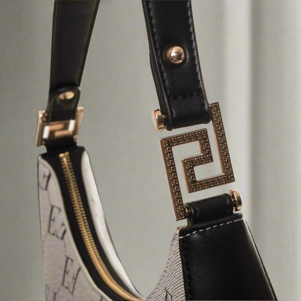 Close-up of a handbag with a decorative strap and buckle on a white background