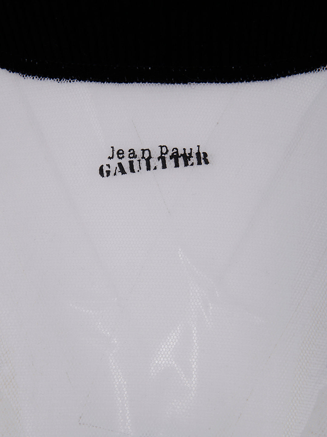 Close-up of a garment with 'Jean Paul Gaultier' branding on a white background.