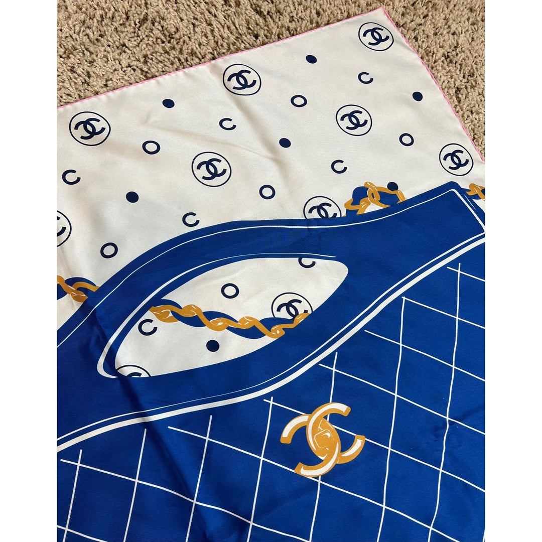 Two fabric swatches with Chanel logos, one white with black logos and the other blue with a grid pattern and gold logo.