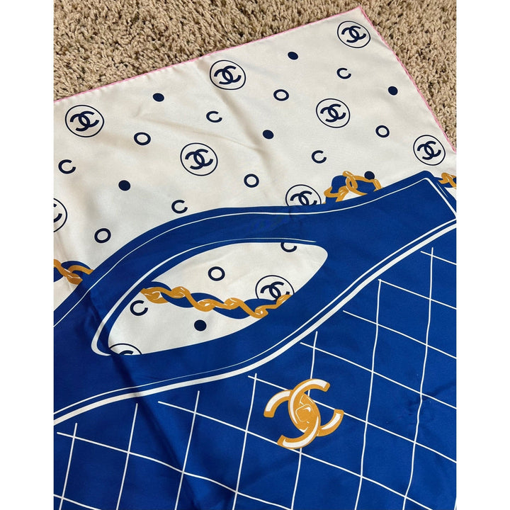 Two fabric swatches with Chanel logos, one white with black logos and the other blue with a grid pattern and gold logo.