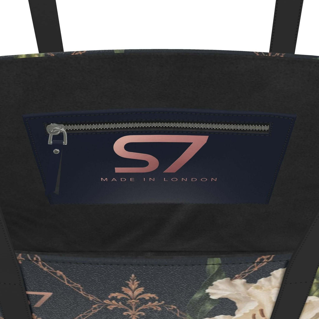 S7 Midnight Conservatory leather tote with ivory gladiolus, burgundy orchids and rose-gold monogram lattice on midnight navy.