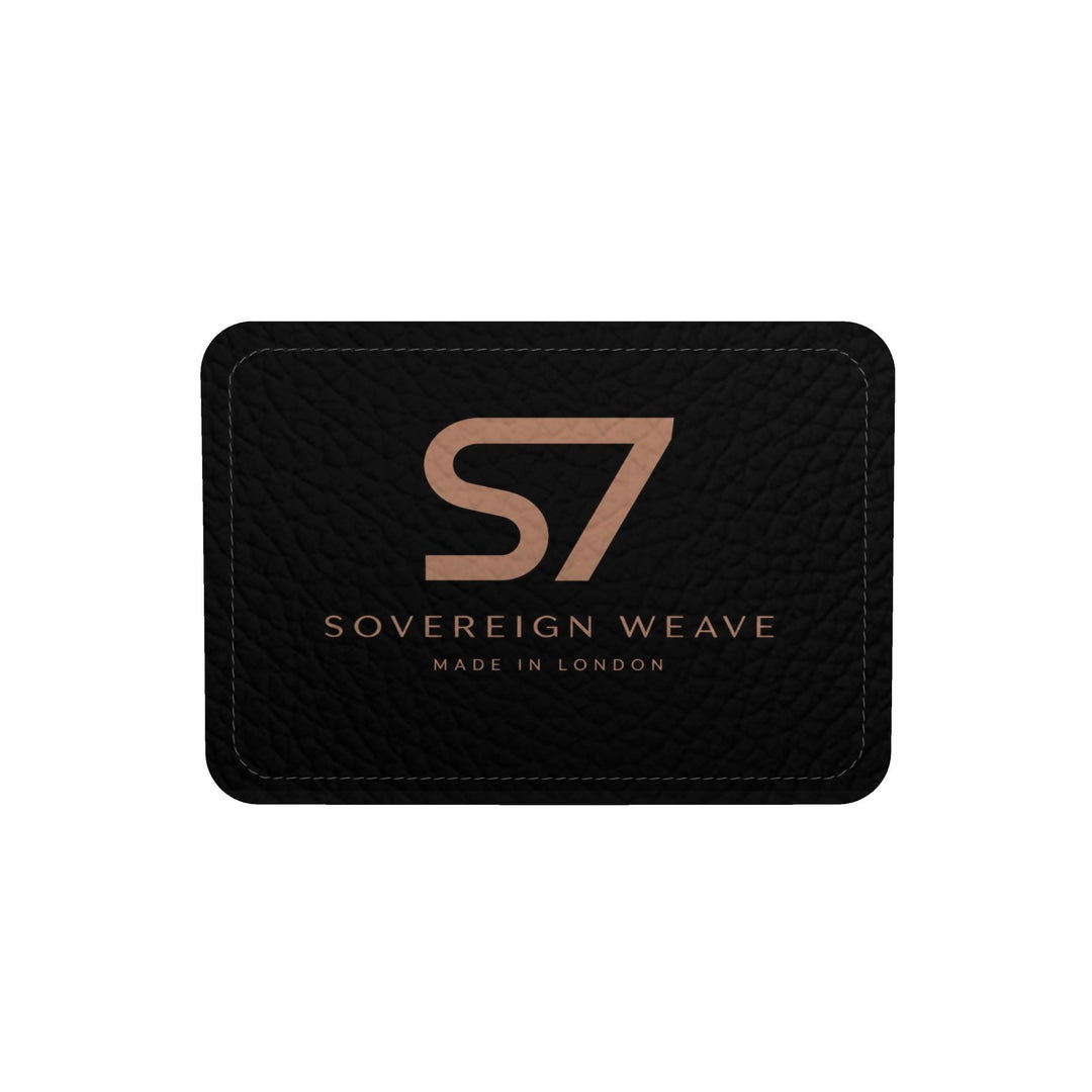 S7 Sovereign Weave leather duffle bag with a black-and-charcoal interlocking diamond pattern, spaced rose-gold-tone S7 logos and black handles.