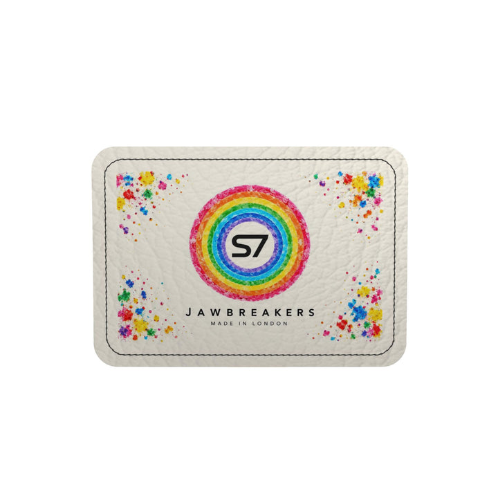 A square white textured card or patch with rounded corners, featuring a colorful rainbow ring with the black &