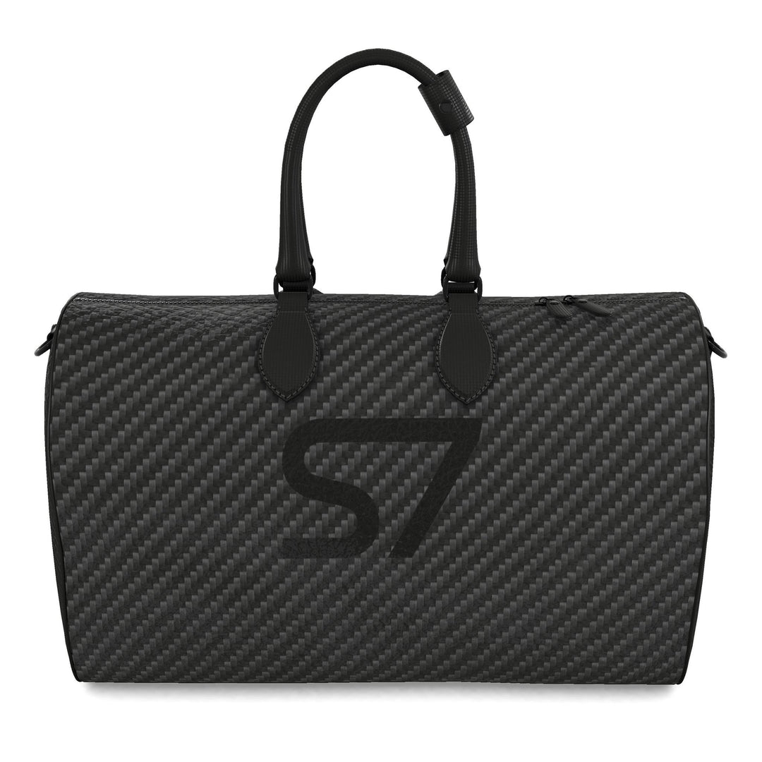 S7 Carbon Noir leather duffle bag with a graphite carbon-fiber-inspired print, centered black S7 monogram, black handles and solid black end panels.