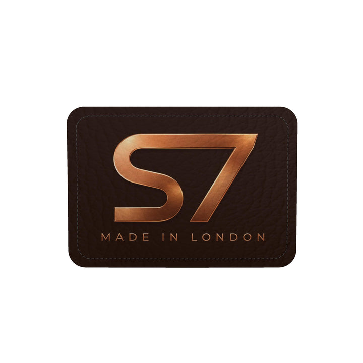 S7 Molten Copper bag with dimensional copper monogram print, espresso brown side panels, and gold-tone hardware.