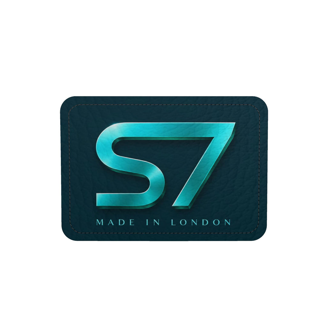 S7 Electric Lagoon bag featuring dimensional turquoise monograms, midnight teal side panels, and nickel-tone hardware.