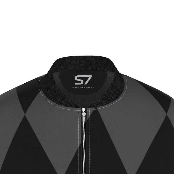 Front view of S7 bomber jacket with elongated black and charcoal harlequin diamonds, black ribbed trim, and a zip closure.