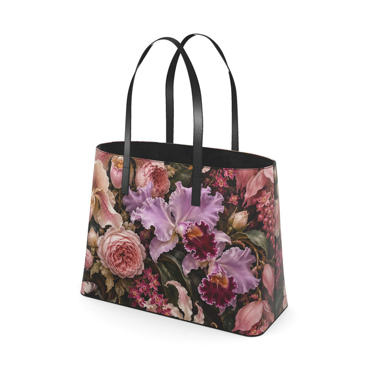 S7 Orchid Reverie leather tote bag featuring blush and lilac flowers, two butterflies, and gold-toned botanical artwork on deep plum with black handles.