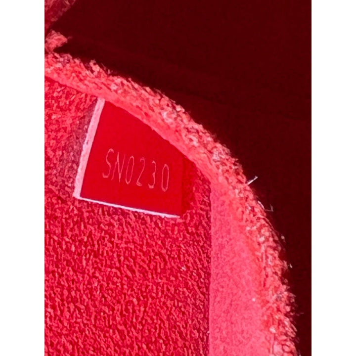 Close-up of a textured red surface with a label displaying 'SN0230'.